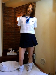 Reiko posing in her skimpy schoolgirl uniform before she strips down to suck a cock